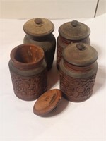 Four wooden carved containers with lid
