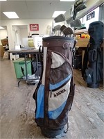 Brown and blue golf bag with clubs by Datrek