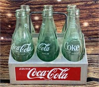 Vintage Coke bottles in metal Coca-Cola carrier