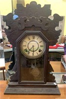 Antique gingerbread mantle clock with a glass