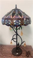 Stained glass table lamp with a curved vine and