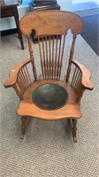 Antique pressed back rocking chair with an old