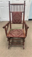 Antique platform rocker with a floral burgundy