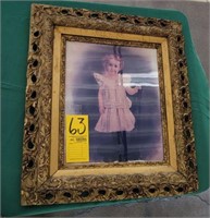 gold framed picture of vintage girl in pink