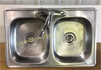 Double stainless steel sink with faucet.