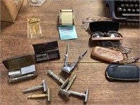 Old safety razors, glasses, travel alarm