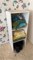 Small shelving unit with towels and pair of boots