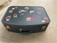 Vintage suitcase w/ travel stickers.