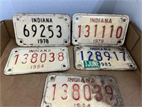 5 old motorcycle license plates.