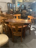 Round wooden dining room table with four chairs