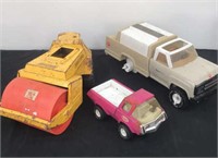 A group of vintage trucks and tractors missing a