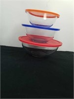 Three stackable Pyrex glass bowls with lids