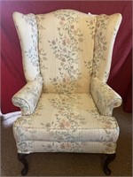 High back wing chair in floral upholstery on