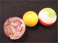 Three art glass marbles; one 4 1/2" diameter,