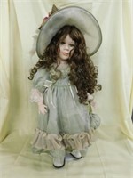 Bisque head / limbs doll, on stand, in green