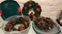 Three decorated wreaths with two bins