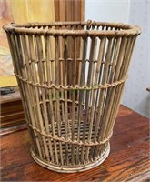 Vintage wicker wastebasket stands 15 inches tall.