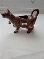 A brown souvenir cow creamer