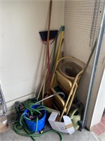 Assorted brooms and gardening tools