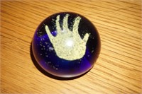 Blue paperweight with yellow hand print