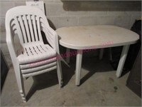 White plastic table & 4 stack chairs (basement)
