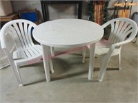 White plastic table & 2 stack chairs (basement)