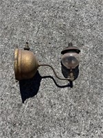 Wall-mounted brass Tilley lamp.
