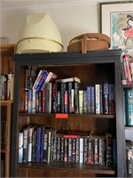 Two Shelves Full of Books and Items on top