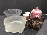 Asian-themed tea pots, one with matching cups and