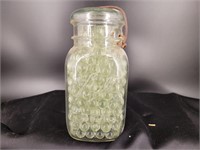 Ball jar with glass lid full of clear marbles