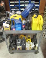 Rolling shop cart with various oils. Note some