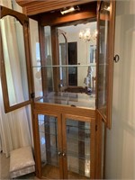 Tall oak lighted glass 
curio cabinet