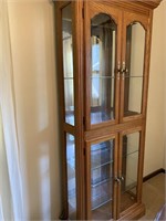 Tall oak lighted glass 
curio cabinet