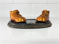 Vintage copper baby shoes on stand