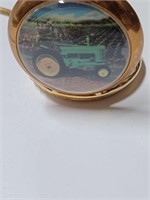 Green Tractor on Front of A Gold Tone Pocket Watch