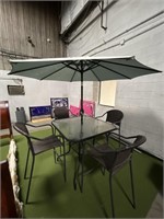 Glass table with chairs and umbrella.