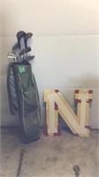Golf clubs and metal Nebraska sign