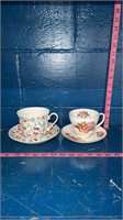 Two cups with matching saucers