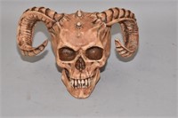 A SATANIC HUMAN SKULL WITH RAMS HORNS AND CANINE