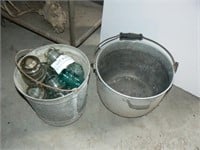 Galvanized and aluminum pails filled with glass