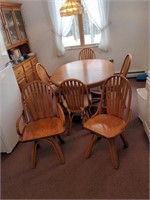 Oak pedestal table with 6 swivel chairs and extra