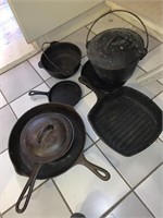 Lot of nine pieces of cast iron cookware.