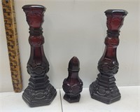 A collection of three ruby red Avon decanters