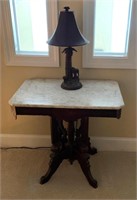 Marble Top Table With Wooden Base and a Lamp