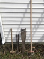 FOUR TOOLS A SLEDGEHAMMER SHEARS A HAND SAW AND