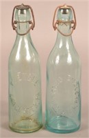 Two Fred Engle Embossed Aqua Blob Top Bottles.