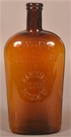 S.C. Miller Liquors Embossed Amber Quart Flask.