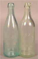 Two Chas. Zech Embossed Aqua Blob Top Bottles.