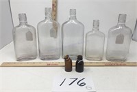 Five whiskey bottles; two brown unique bottles