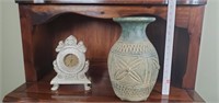 Ornate clock and pottery vase.